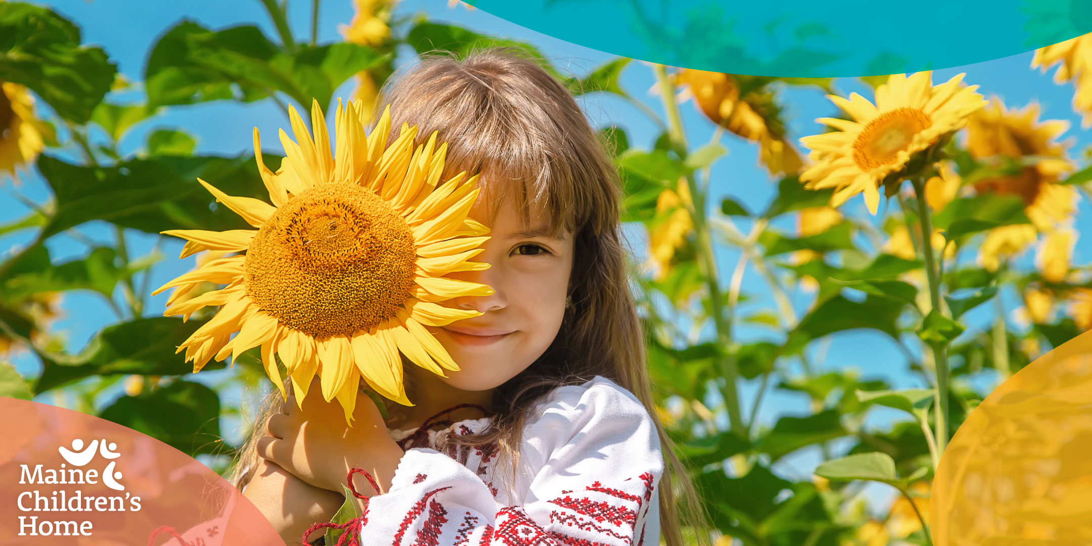 A child smiles in a field of sunflowers.