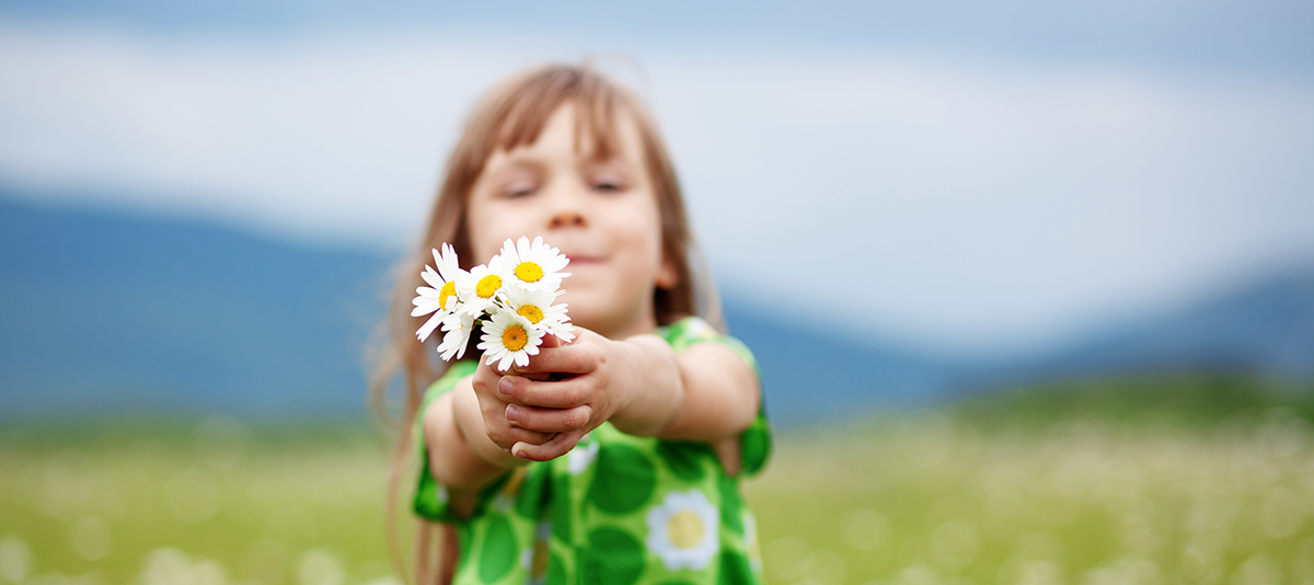 Girl holds out daisies