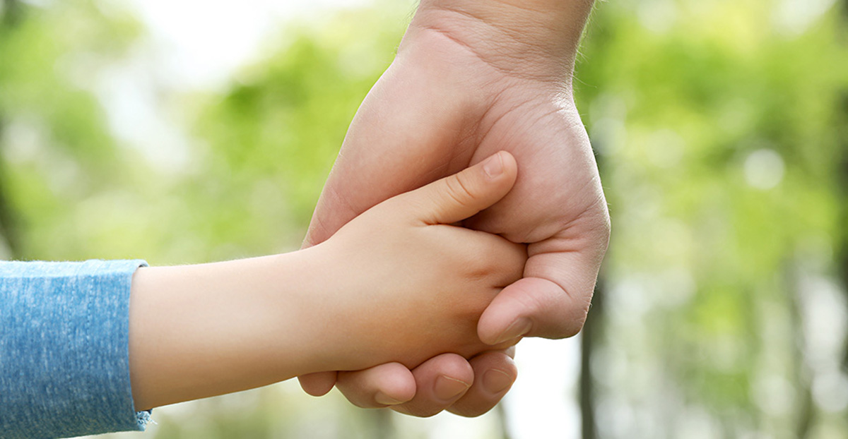 Child and parent holding hands