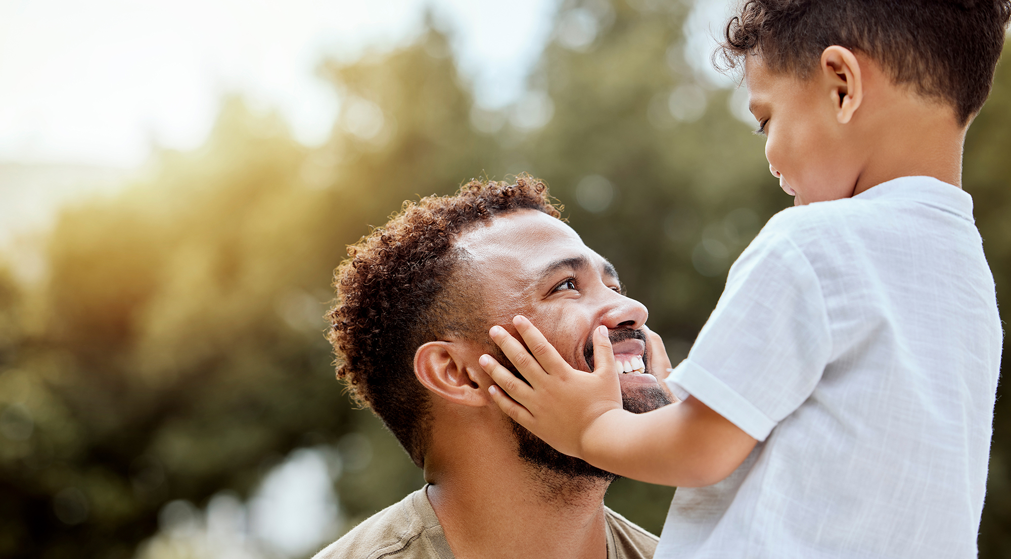 Father and young son looking at each other smiling