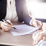 A person is reviewing paperwork at a table.