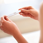A person holds a positive pregnancy test.
