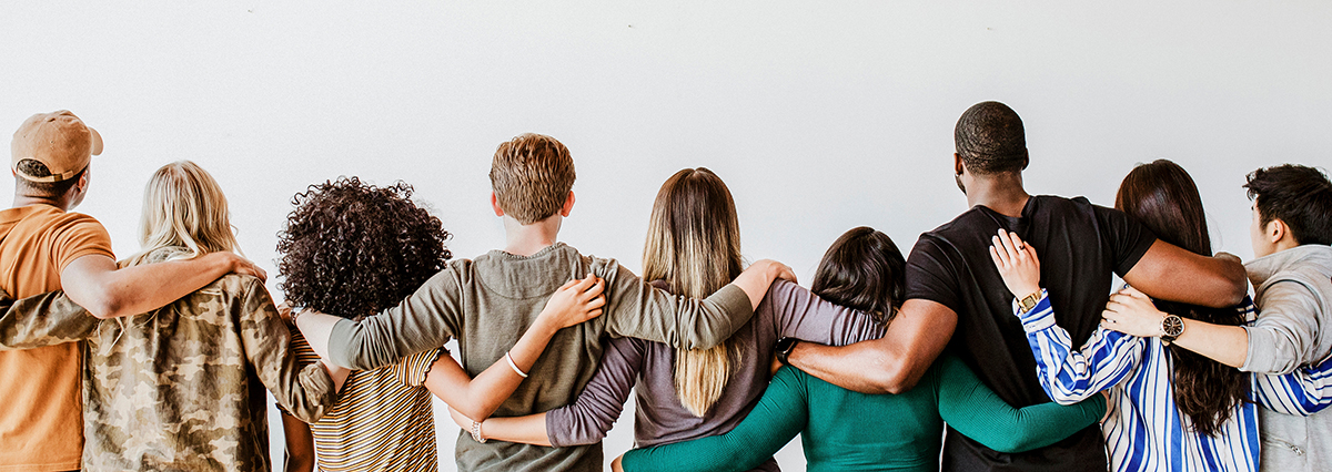 A group of volunteers stand arm in arm