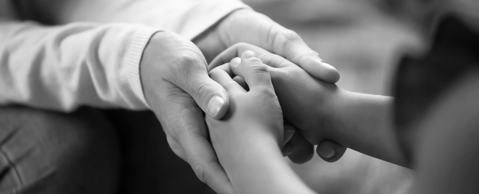 Adult holding the hands of a child